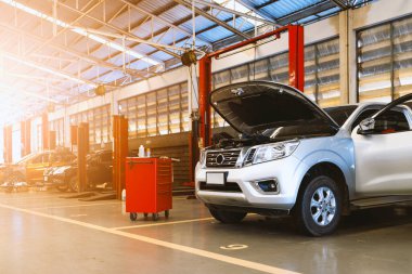 Garaj servis istasyonunda araba tamiri. Arka planda hafif odaklı ve ışığın üstünde.