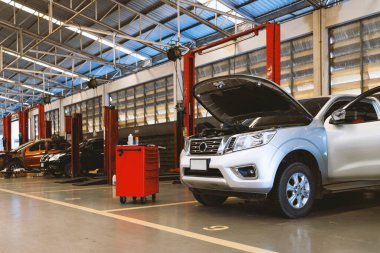 Garaj servis istasyonunda araba tamiri. Arka planda hafif odaklı ve ışığın üstünde.