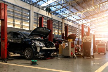 Garaj servis istasyonunda araba tamiri. Arka planda hafif odaklı ve ışığın üstünde.