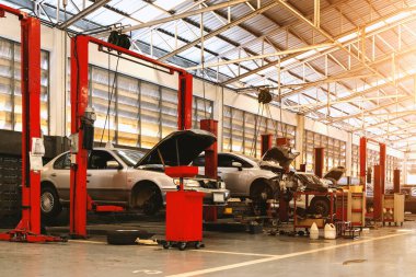 Garaj servis istasyonunda araba tamiri. Arka planda hafif odaklı ve ışığın üstünde.