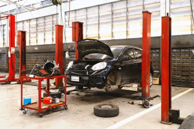 Garaj servis istasyonunda araba tamiri. Arka planda hafif odaklı ve ışığın üstünde.