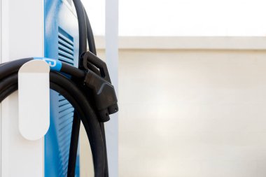 Açık hava park yerindeki elektrikli araba şarj istasyonu yumuşak odaklı ve arka planda