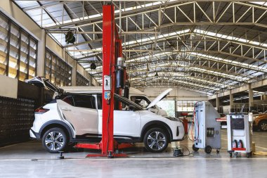 Otomobil tamirhanesinde hafif odaklı ve arka planında ışık olan bir araba.