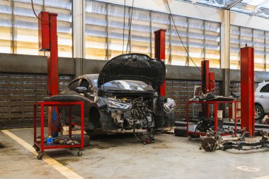 Otomobil tamirhanesinde hafif odaklı ve arka planında ışık olan bir araba.