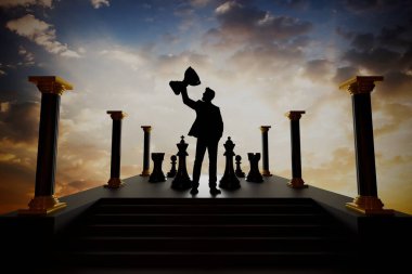Satranç taşlarıyla 'hedefler ve büyüme' sözcüğünün yer aldığı ve arka planda stratejik planlamayı sembolize eden ve hedeflere ulaşmayı sembolize eden bir hedef