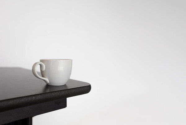 чашка белого кофе, расположенная на деревянном столе возле яркого окна, запечатлевает спокойный момент современной простоты и естественного света. Перфект для праздничных акций, маркетинга и праздничных скидок