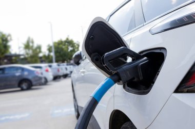 Bir şarj istasyonuna bağlı elektrikli bir aracın yakın çekimi sürdürülebilir ve çevre dostu ulaşım.