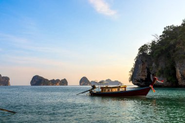 Tayland, Krabi 'deki Koh Phakbia adasında dinlenen güzel uzun kuyruklu tekne berrak mavi suları, kireçtaşı kayalıkları ve sakin bir tropikal atmosferi var..