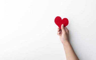 Beyaz arka planda kırmızı bir kalbi tutan bir el. Aşkı, şefkati ve fedakarlığı simgeliyor. İlişkiler, yardım ve sağlık konuları için mükemmel..  