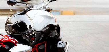Bigbike koltuğunda dinlenen siyah bir motosiklet kaskının yakın çekimi güvenliği, korumayı ve binicilik takımlarını sembolize ediyor..