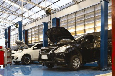Araba bakım teknisyeni atölyede, motor tamirine odaklanıyor. Gösterişli uzmanlık ve adanmışlık. Otomotiv, tamir ve teknik endüstri görselleri için mükemmel.