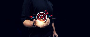 İşadamı elinde okla parlayan bir hedef tutuyor, dijital stratejiyi, başarıyı, hedef başarısını ve iş büyümesini simgeliyor..