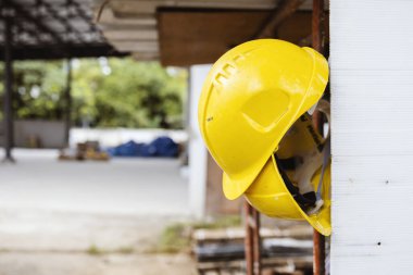 İnşaat alanında asılı duran sarı başlık, mühendisliği, kalifiye işçiliği ve endüstriyel güvenlik önlemlerini temsil ediyor.