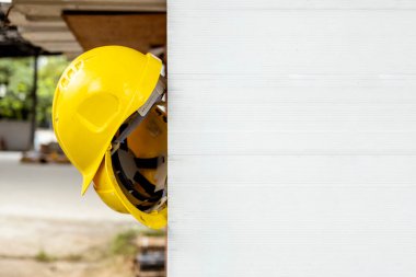 İnşaat alanında asılı duran sarı başlık, mühendisliği, kalifiye işçiliği ve endüstriyel güvenlik önlemlerini temsil ediyor.