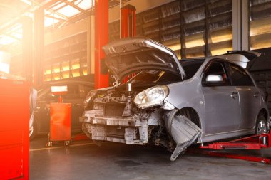 Garaj servis istasyonunda araba tamiri. Arka planda hafif odaklı ve ışığın üstünde.