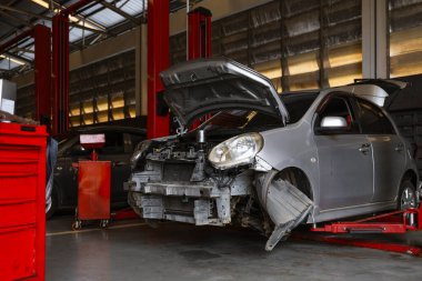 Garaj servis istasyonunda araba tamiri. Arka planda hafif odaklı ve ışığın üstünde.