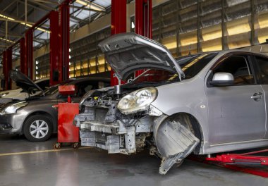 Garaj servis istasyonunda araba tamiri. Arka planda hafif odaklı ve ışığın üstünde.