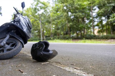 Yolda kask takılı motosiklet kazası ve hayat kurtarma mesajı, yol güvenliği ve farkındalık kavramı