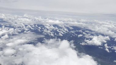 footage from an airplane window. Scenic view over beautiful white clouds and sky. Concept of freedom, travel, journey and transportation.