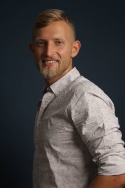 Kendine güvenen sarışın genç bir adam, stüdyo arka planında bir portre. İş, kanepe, ofis kavramı