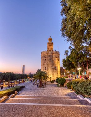 Günbatımında Guadalquivir nehrinin üzerinde Seville, Endülüs, İspanya 'daki Torre del Oro manzarası.