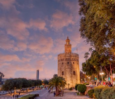 Günbatımında Guadalquivir nehrinin üzerinde Seville, Endülüs, İspanya 'daki Torre del Oro manzarası.