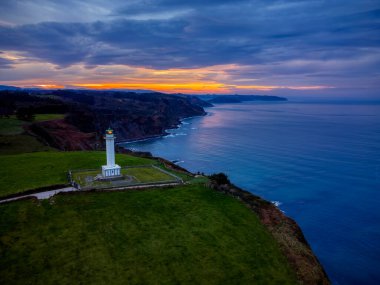 Günbatımında Lastres 'in deniz feneri Luces, Asturias, İspanya' da yer alır..