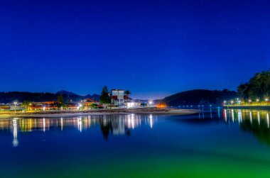 Ribadesella limanına giriş, arka planda Santa Marina plajı, yıldızlı bir gecede. Asturias, İspanya.