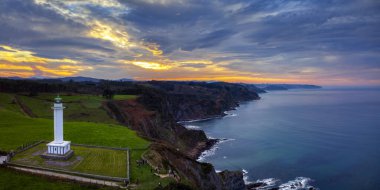 Günbatımında Lastres 'in deniz feneri Luces, Asturias, İspanya' da yer alır..