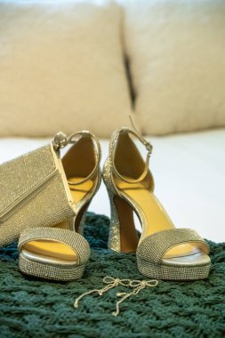 Gümüş renkli parlak ayakkabılar, balo ya da düğün aksesuarlarını göstermek için el çantası ve küpelerle bir yatakta düzenlenir.
