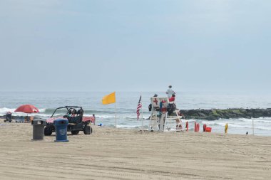 Asbury Park, New Jersey - 29 Temmuz 2024: Cankurtaranlar cankurtaran standında oturup yüzücüleri güvende tutarlar