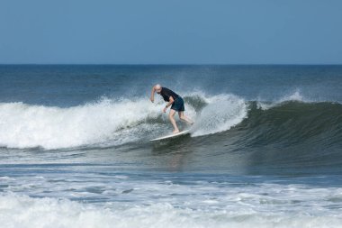 Deal, New Jersey - 10 Ağustos 2024: sörfçüler Debby Kasırgası 'nın kalıntılarında Deal açıklarında sörf yapıyor.