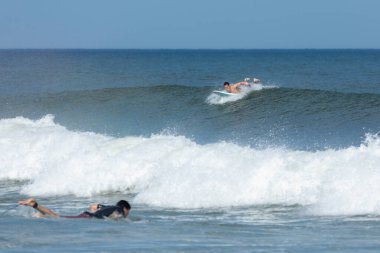 Deal, New Jersey - 10 Ağustos 2024: sörfçüler Debby Kasırgası 'nın kalıntılarında Deal açıklarında sörf yapıyor.