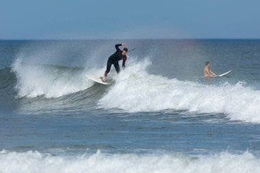 Deal, New Jersey - 10 Ağustos 2024: sörfçüler Debby Kasırgası 'nın kalıntılarında Deal açıklarında sörf yapıyor.