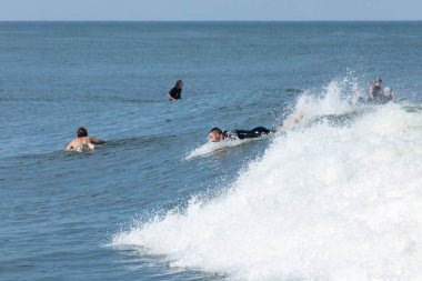 Deal, New Jersey - 10 Ağustos 2024: sörfçüler Debby Kasırgası 'nın kalıntılarında Deal açıklarında sörf yapıyor.