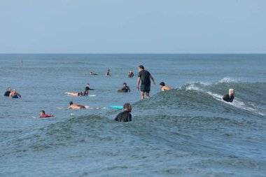 Deal, New Jersey - 10 Ağustos 2024: sörfçüler Debby Kasırgası 'nın kalıntılarında Deal açıklarında sörf yapıyor.