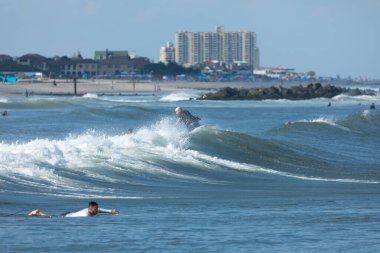 Deal, New Jersey - 10 Ağustos 2024: sörfçüler Debby Kasırgası 'nın kalıntılarında Deal açıklarında sörf yapıyor.