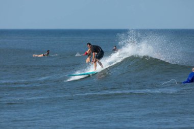 Deal, New Jersey - 10 Ağustos 2024: sörfçüler Debby Kasırgası 'nın kalıntılarında Deal açıklarında sörf yapıyor.