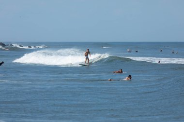 Deal, New Jersey - 10 Ağustos 2024: sörfçüler Debby Kasırgası 'nın kalıntılarında Deal açıklarında sörf yapıyor.