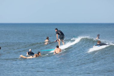 Deal, New Jersey - 10 Ağustos 2024: sörfçüler Debby Kasırgası 'nın kalıntılarında Deal açıklarında sörf yapıyor.