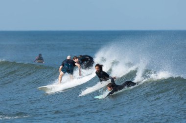 Deal, New Jersey - 10 Ağustos 2024: sörfçüler Debby Kasırgası 'nın kalıntılarında Deal açıklarında sörf yapıyor.