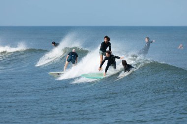 Deal, New Jersey - 10 Ağustos 2024: sörfçüler Debby Kasırgası 'nın kalıntılarında Deal açıklarında sörf yapıyor.