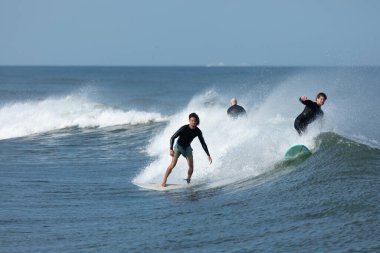 Deal, New Jersey - 10 Ağustos 2024: sörfçüler Debby Kasırgası 'nın kalıntılarında Deal açıklarında sörf yapıyor.