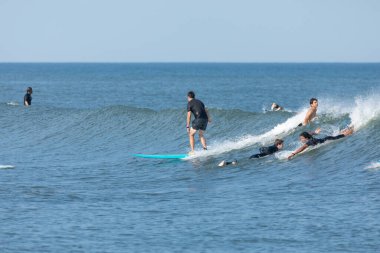 Deal, New Jersey - 10 Ağustos 2024: sörfçüler Debby Kasırgası 'nın kalıntılarında Deal açıklarında sörf yapıyor.