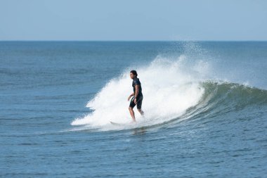 Deal, New Jersey - 10 Ağustos 2024: sörfçüler Debby Kasırgası 'nın kalıntılarında Deal açıklarında sörf yapıyor.