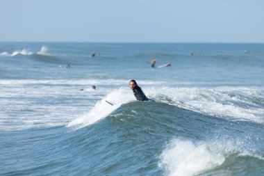 Deal, New Jersey - 10 Ağustos 2024: sörfçüler Debby Kasırgası 'nın kalıntılarında Deal açıklarında sörf yapıyor.