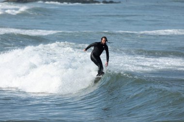 Deal, New Jersey - 10 Ağustos 2024: sörfçüler Debby Kasırgası 'nın kalıntılarında Deal açıklarında sörf yapıyor.