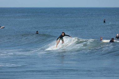 Deal, New Jersey - 10 Ağustos 2024: sörfçüler Debby Kasırgası 'nın kalıntılarında Deal açıklarında sörf yapıyor.