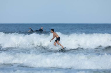 Deal, New Jersey - 10 Ağustos 2024: sörfçüler Debby Kasırgası 'nın kalıntılarında Deal açıklarında sörf yapıyor.