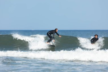 Deal, New Jersey - 10 Ağustos 2024: sörfçüler Debby Kasırgası 'nın kalıntılarında Deal açıklarında sörf yapıyor.